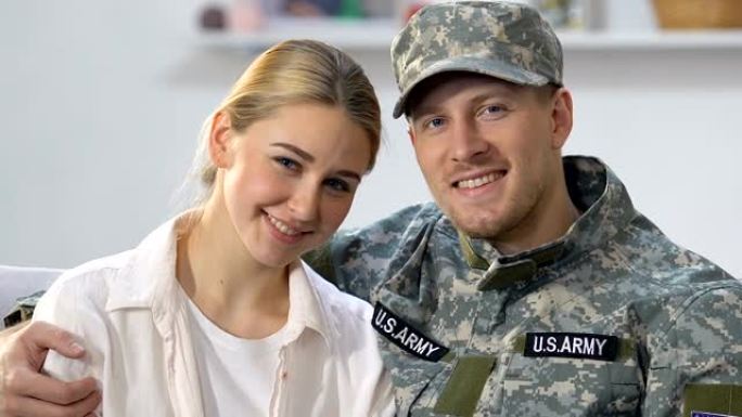 英俊的军事特工拥抱着漂亮的妻子，年轻的情侣，美国民族