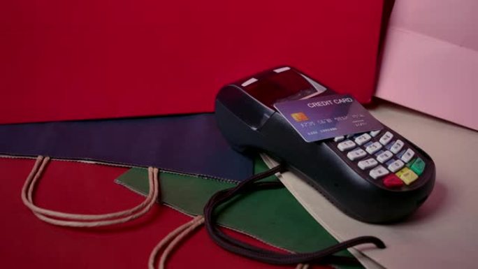 信用卡套机和模型信用卡放在购物商店各种颜色的纸袋上