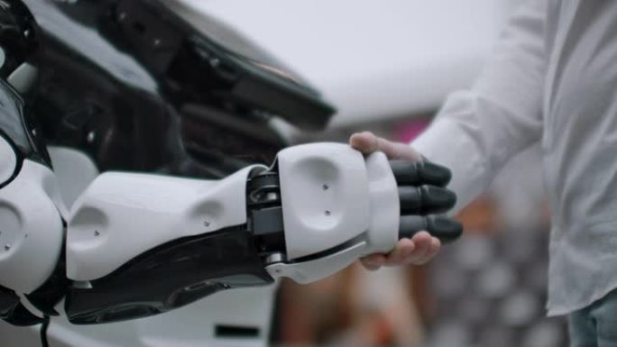 商人的手与Android机器人握手。人类与人工智能互动的概念