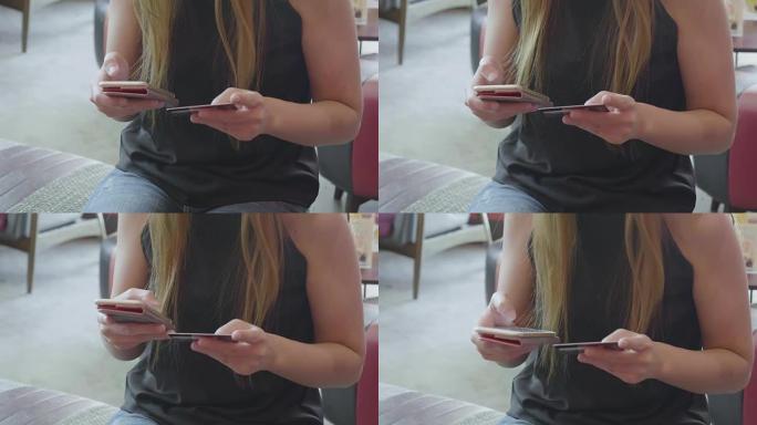 亚洲女子手握信用卡并使用智能手机