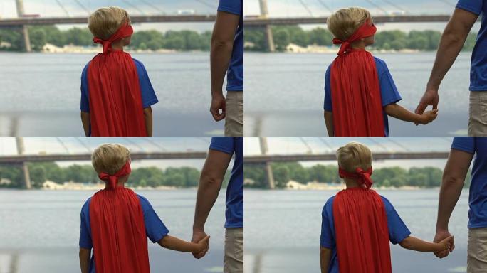 穿着超级英雄服装的不安全男孩找到父亲的支持，手牵手
