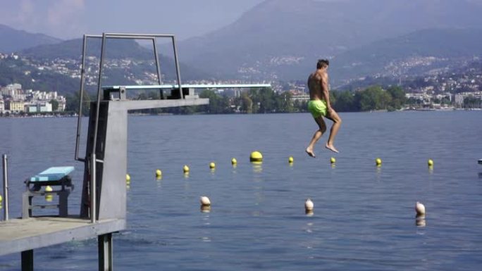 男子从跳水板跳入湖中