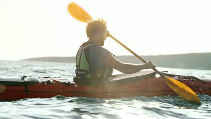 SLO MO TS男运动员在阳光下在海上划皮艇