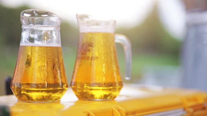 在婚礼招待会上，背景模糊的户外桌子上摆着两罐冰镇啤酒。