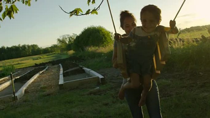 母亲在日落时推她的小男孩