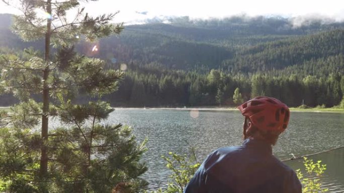 山地车手在湖的边缘停下来展望前方