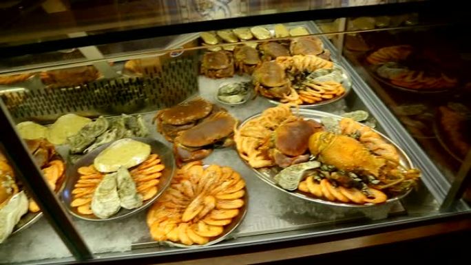 各种各样的海鲜躺在小餐馆的陈列柜上，海菜