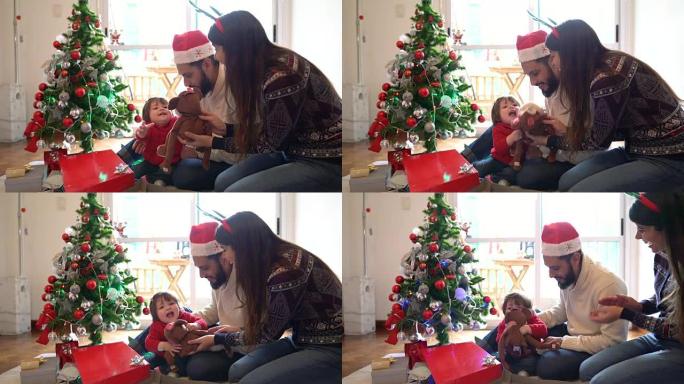 美丽的拉丁美洲家庭打开圣诞礼物和小女孩兴奋地收到玩具