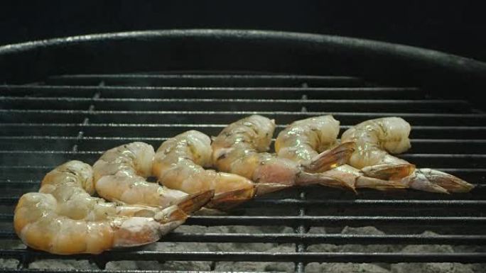 一排虾在烧烤架上的热煤上煮