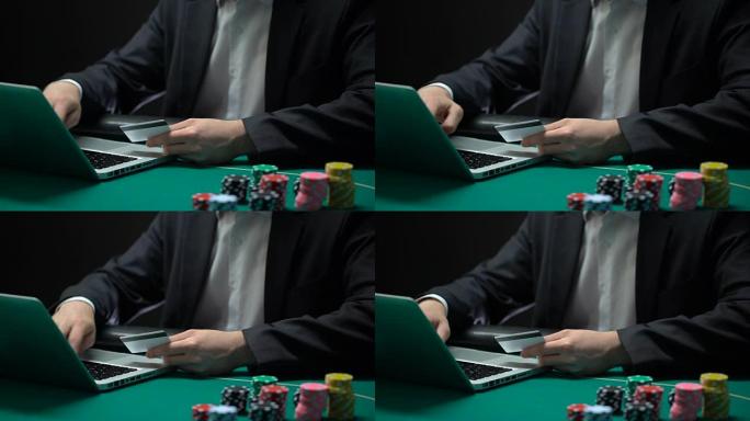 男性在笔记本电脑上输入卡号，桌上的芯片，在线赌博