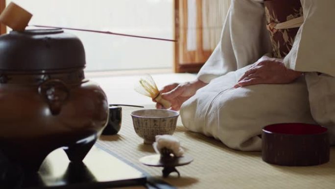 在传统的日本茶道上主持搅拌茶并提供碗