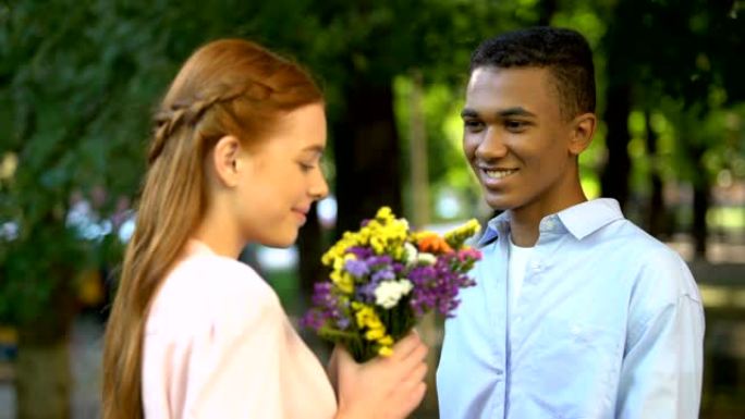 可爱的非洲裔美国少年男孩向害羞的女友献花