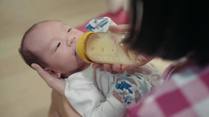 妈妈奶瓶喂她的男婴