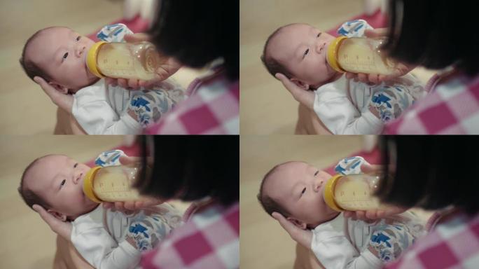妈妈奶瓶喂她的男婴