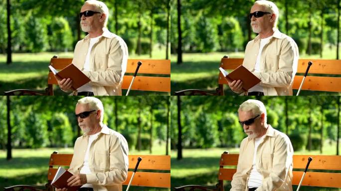 戴深色墨镜的盲人厌倦了在盲文中看书，坐在公园里