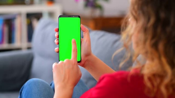 女人在家里使用色度键屏幕智能手机滑动和点击