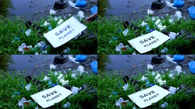 女人在湖附近的露天垃圾场上放了带有save planet短语的纸板