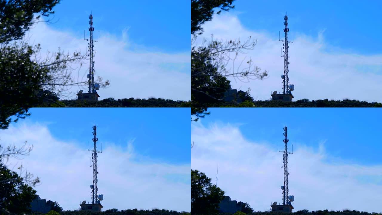 高高的电信塔站在树丛中的山顶上