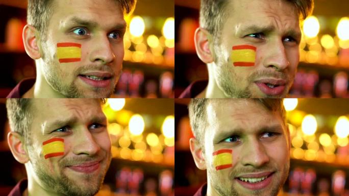 男球迷对国家足球队的失利感到不满，西班牙国旗在脸颊上