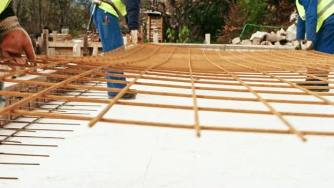 建筑工人在建筑工地携带大型钢丝网