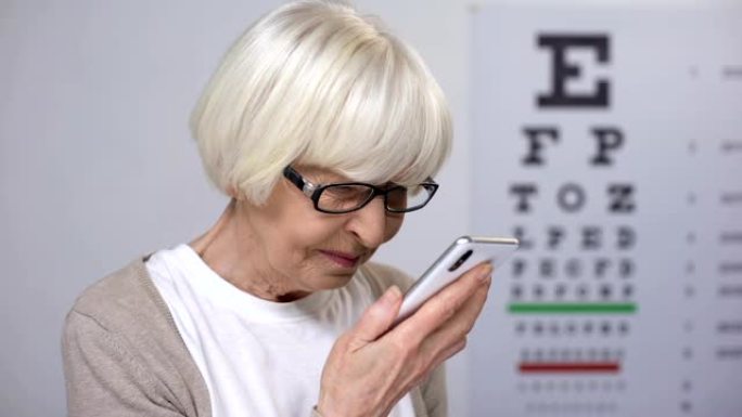 试图在智能手机上阅读的老年女性，字体较小，视力不佳