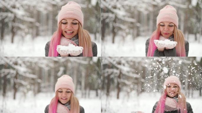 慢动作，一个穿着夹克帽子和围巾的女人在冬天的森林里手里拿着雪吹向镜头扔雪