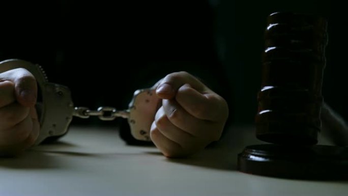 法官把手铐放在桌子上，黑暗的法庭上，因贿赂和腐败被捕