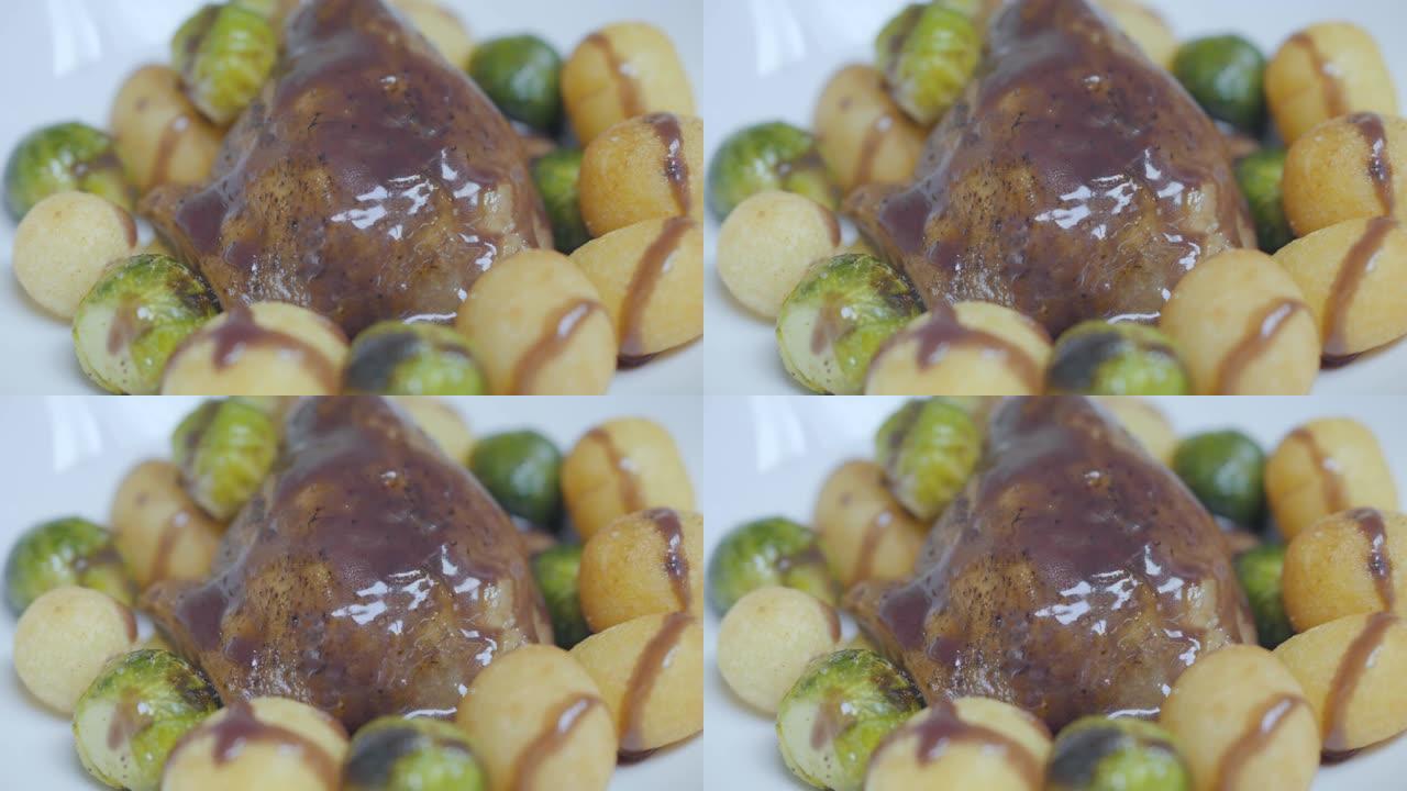 美味的鸭肉和酱汁放在盘子里，新鲜烤的豆芽和奶酪球合起来。
