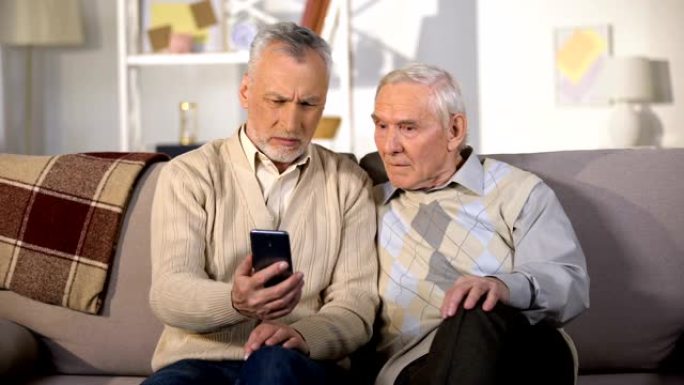 使用现代技术展示新的智能手机老年朋友的高级男性