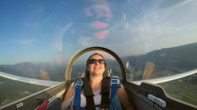 LD滑翔机循环和年轻女乘客在阳光明媚的天空中玩乐