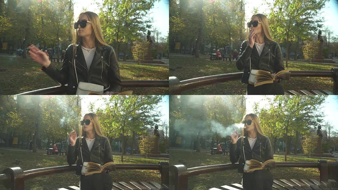 带着书的年轻女子在公园里吸烟