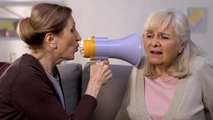 老妇人通过扩音器向朋友大喊，听力损失疾病，问题
