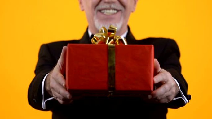 高级男子展示红色礼品盒，生日礼物，节日惊喜，感情