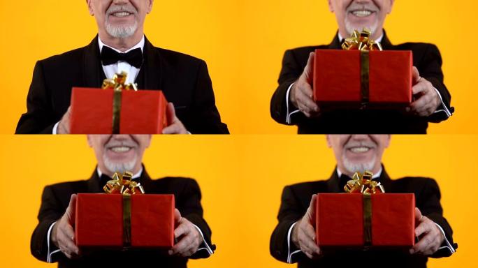 高级男子展示红色礼品盒，生日礼物，节日惊喜，感情