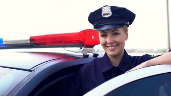 美丽的女警察在服务帽微笑着对着镜头，保护城市的女人