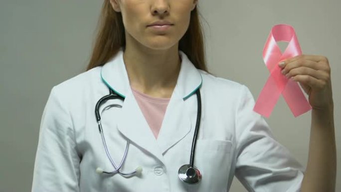 医生手持粉红丝带，认识乳腺癌概念，预防体检