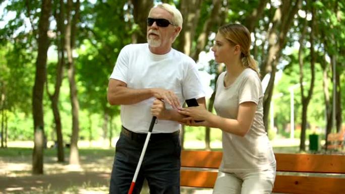 善良的女儿帮助盲人老爸在公园散步，关心关系，同情