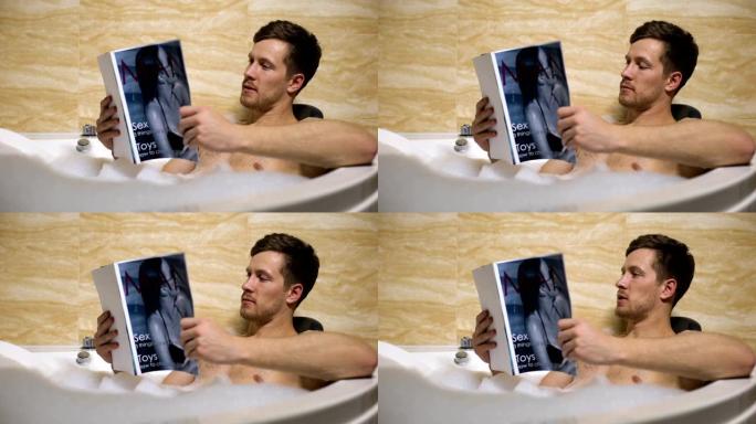 有男子气概的家伙洗着温暖的澡，读着男性杂志，新鲜的新闻
