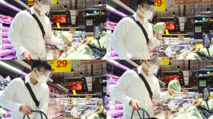 亚洲男人戴着面具保护和他在超市购物。