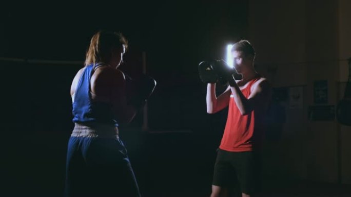 年轻的成年女子与教练一起进行跆拳道训练