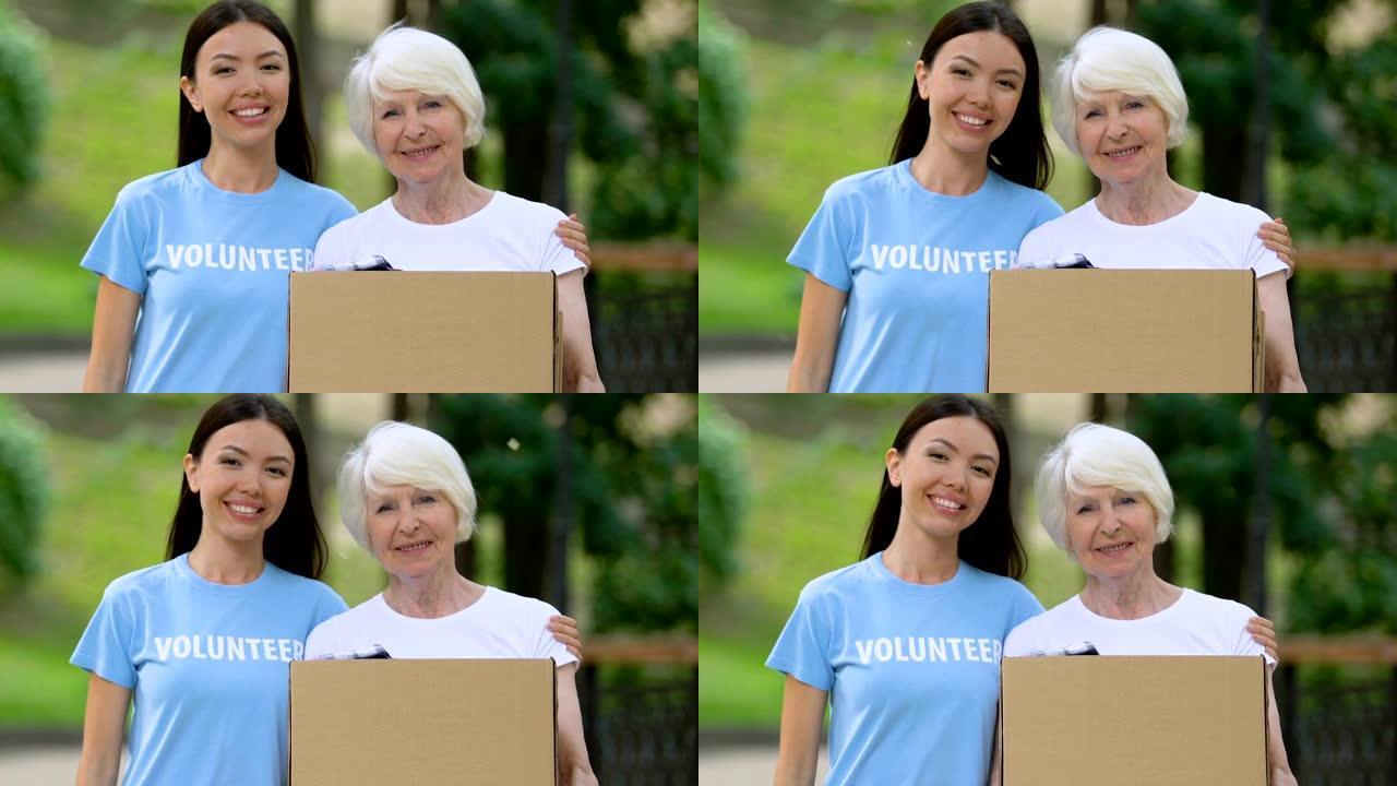 义工抱抱老妇人拿著衣服箱子社会支持捐款
