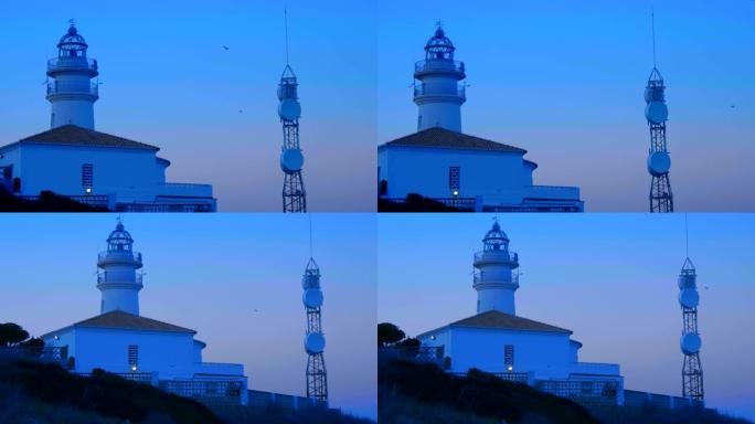 灯塔在海边的悬崖上被扇形灯照亮