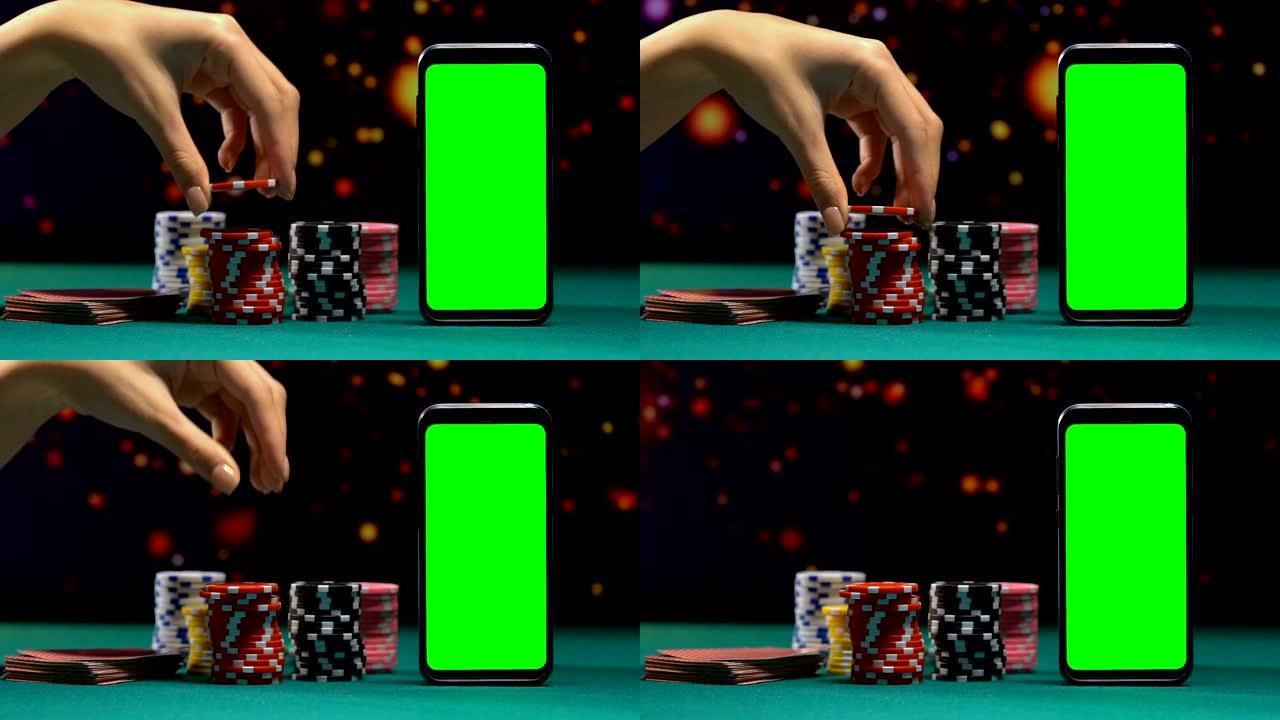 女人将令牌添加到大堆中，带有绿屏的智能手机，在线赌场
