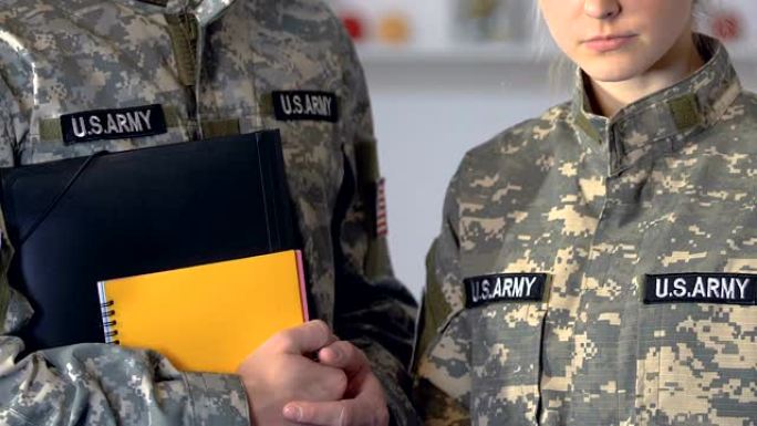 男女军人学生拿着笔记本，进行学院教育、训练