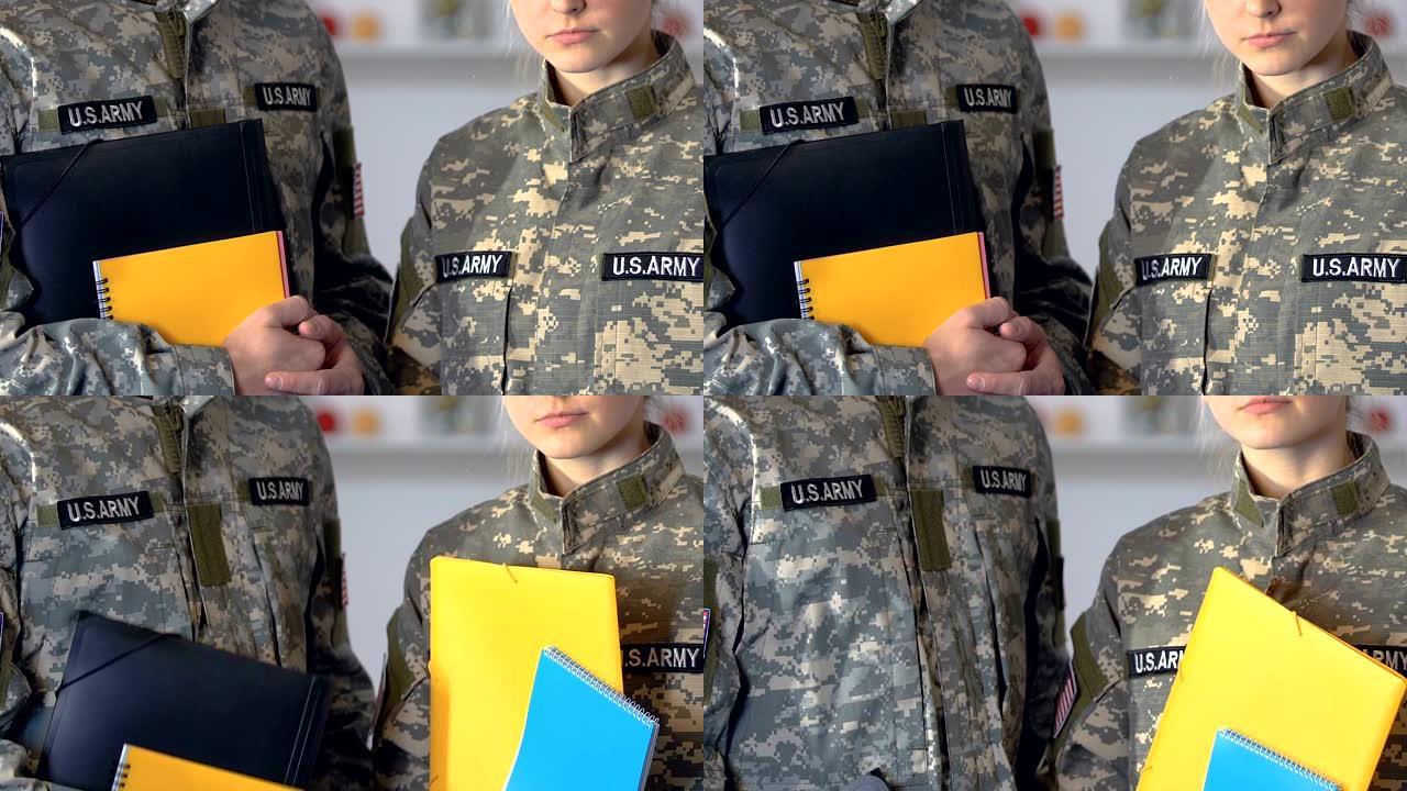 男女军人学生拿着笔记本，进行学院教育、训练