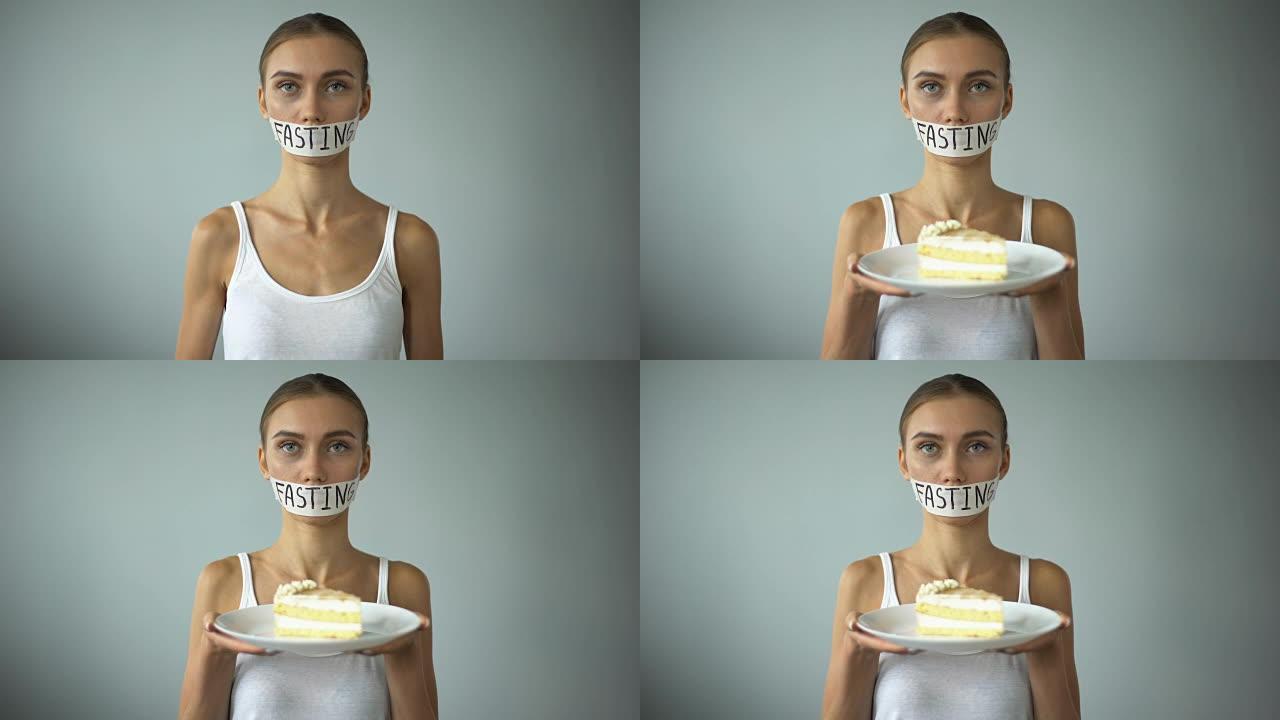 厌食症的女孩拿着馅饼，在胶带上写的禁食词，禁止糖果