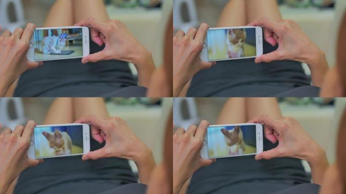 在智能手机上观看视频的女性的肩膀镜头