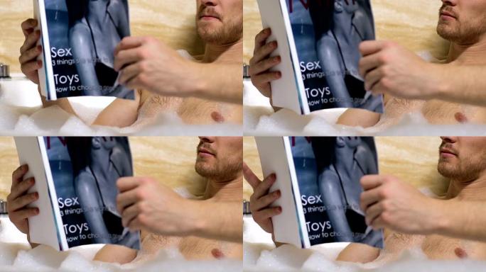 年轻英俊的男性阅读成人杂志，在浴缸里放松，休闲时间