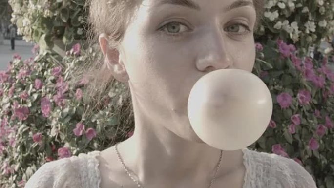 年轻女子用口香糖制造一个大泡沫