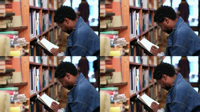 男人在书店里蹲在书架上读书